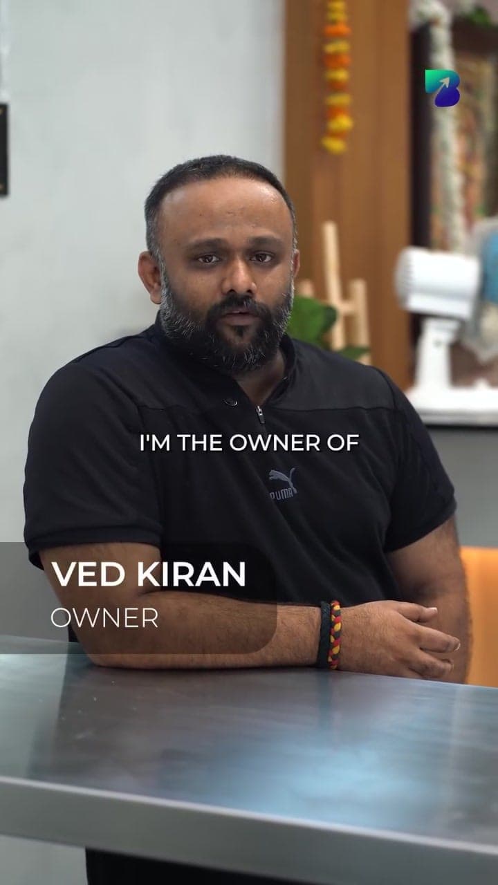 Ved Kiran, owner of Rajeshwari Café, speaking to camera at the café counter